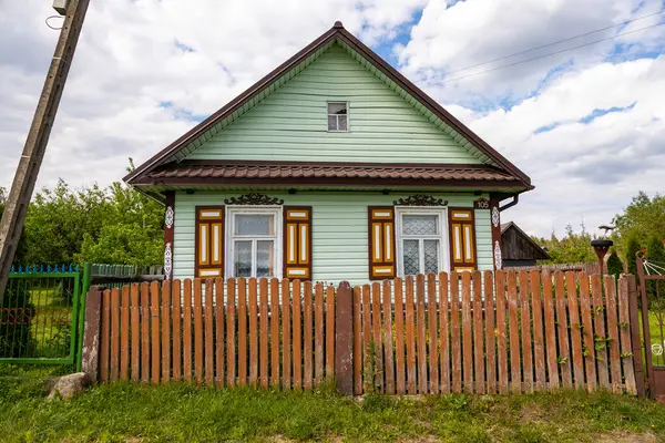 Soce Village, Podlasie, Polonya 'da sarı kepenkleri ve yeşil cephesi olan parlak ahşap kulübe..