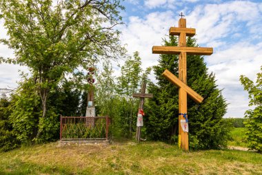 Soce, Polonya - 4 Haziran 2021: Geleneksel Ortodoks yol kenarı haçları ve ağaçlar ve yeşilliklerle çevrili anıtlar.