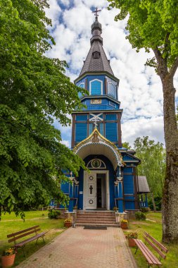 Puchly, Polonya - 4 Haziran 2021: Ağaçlarla çevrili mavi ahşap Ortodoks Kilisesi.