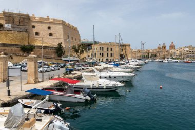 Valletta, Malta - 21 Haziran 2021: Yat ve yelkenliler tarihi şehir binaları ve kilise kubbeleri ile marinada demirlediler.