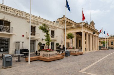 Valletta, Malta 21 Haziran 2021: Şehir merkezinde yeşil ahşap balkonlu geleneksel kireçtaşı bina.