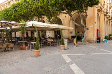 Valletta, Malta 21 Haziran 2021: Şehir merkezinde yeşil ahşap balkonlu geleneksel kireçtaşı bina.