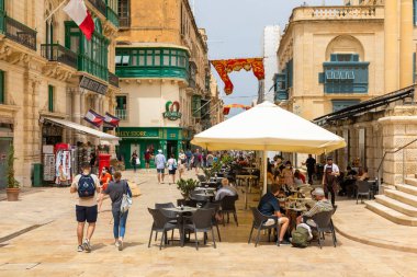 Valletta, Malta 21 Haziran 2021: Şehir merkezinde yeşil ahşap balkonlu geleneksel kireçtaşı bina.