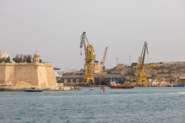 Valetta, Malta 21 Haziran 2021: Körfezin karşısındaki St. Angelo Kalesi 'nde bir adam balık tutuyor..