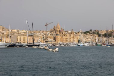 Valetta, Malta 21 Haziran 2021: Körfezin karşısındaki St. Angelo Kalesi 'nde bir adam balık tutuyor..