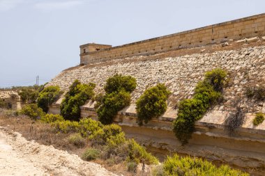 Malta kıyısındaki tarihi bir İngiliz istihkamı olan Delimara Kalesi 'ndeki savunma duvarı ve aşırı gelişmiş siper..