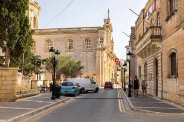 Mdina, Malta - 22 Haziran 2021: Güneşli bir günde eğilmiş ağaçlar, işaretler ve banklarla Howard Gardens 'a giden yol.