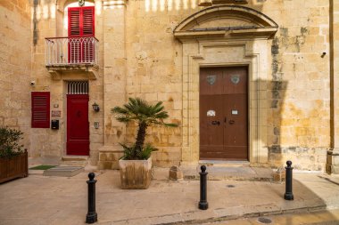 Mdina, Malta - 22 Haziran 2021: Turistler ve tarihi Mdina Kapısı 'nda taş duvarlar ve yakınlarındaki eski toplarla birlikte bir at arabası.