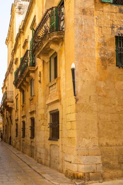 Mdina, Malta 'da balkonları ve yeşil kepenkleri olan geleneksel taş bina..
