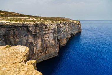 Gozo Malta sahilindeki Akdeniz 'in üzerinde dramatik kireçtaşı kayalıkları yükseliyor..