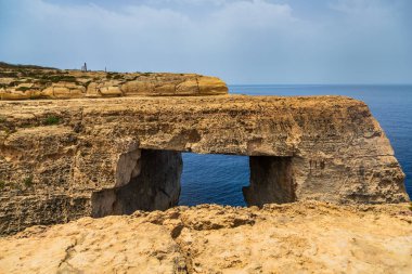 Gozo Malta 'nın engebeli kıyısındaki Akdeniz' e bakan doğal kireçtaşı penceresi.