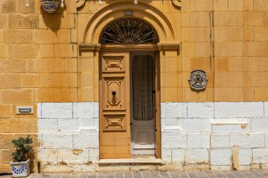 Gozo Malta 'da tarihi bir taş bina üzerinde kemerli çerçeveli ahşap kapı..