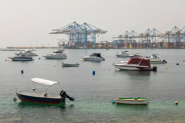 Taht Il-Maqjel, Malta 24 Haziran 2021: Arka planda kireçtaşı kemer ve engebeli kıyı şeridi bulunan turkuaz sulara demirlenmiş yatların yayın manzarası.
