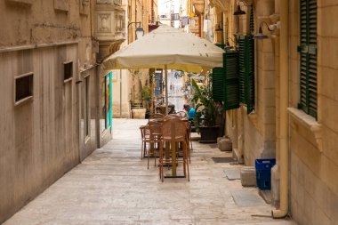 Valletta, Malta 26 Haziran 2021: Geleneksel Malta balkonları ve yokuş yukarı çıkan basamakları olan Dar Taş Sokak.
