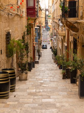 Valletta, Malta 26 Haziran 2021: Geleneksel Malta balkonları ve yokuş yukarı çıkan basamakları olan Dar Taş Sokak.