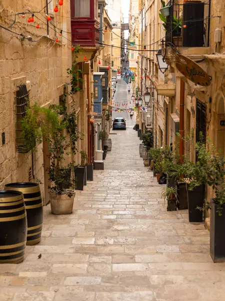 Valletta, Malta 26 Haziran 2021: Geleneksel Malta balkonları ve yokuş yukarı çıkan basamakları olan Dar Taş Sokak.