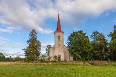 Saaremaa, Estonya 24 Ağustos 2021: Gotik pencereleri ve ahşap kapılarıyla çevrili tarihi taş bir kilisenin girişi.