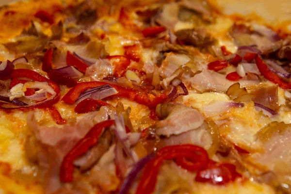 Fresh pizza with onions, pepper, bacon and cheese. Italian cuisine concept, italian pizza, ingridients close up view. Traditional pizzeria, pizza for dinner.