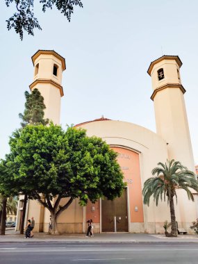 Cezayir, İspanya - 5 Temmuz 2023: modern kilise binası, şehir caddesi. Kilise cephesi, yeşil ağaçlar, Hıristiyan kilisesi. Kilisenin dış görünüşü, dış görünüş.