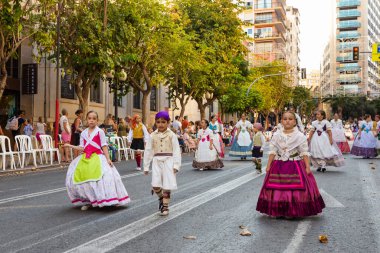 ALICANTE, İSPAN - 25 Haziran 2023: Radyasyonal İspanyol elbisesi içinde yürüyen kızlar ve erkekler, hogueras San Juan festivali. İspanyol elbisesi, festival homoları..