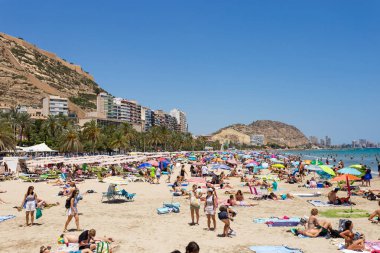 5 Temmuz 2023 Postiguet plajı Alicante, Costa Blanca sahilinde güneşlenen insanlar. Yaz zamanı, deniz tatil köyü, mavi gökyüzü.