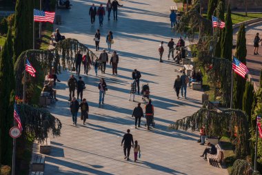 Gürcistan, Tiflis - 30 Ekim 2022: Şehir parkında yürüyen isimsiz bir kalabalık.