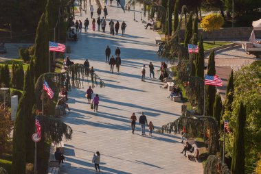 Gürcistan, Tiflis - 30 Ekim 2022: Şehir parkında yürüyen isimsiz bir kalabalık.