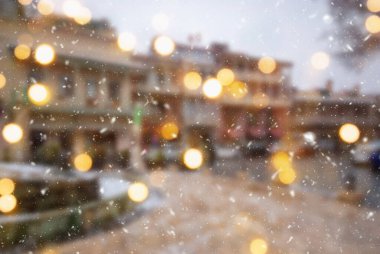 Tiflis şehrinin güzel kış arkaplanı bulanık. Yağan kar ve bokeh ışıklarıyla..