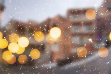 Tiflis şehrinin güzel kış arkaplanı bulanık. Yağan kar ve bokeh ışıklarıyla..