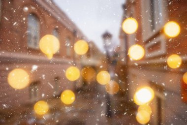 Tiflis şehrinin güzel kış arkaplanı bulanık. Yağan kar ve bokeh ışıklarıyla..