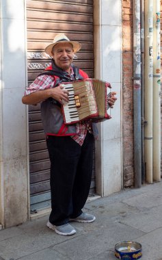 October 31, 2022 - Venice, Italy: Man playing the harmonica in the streets. Music concept.