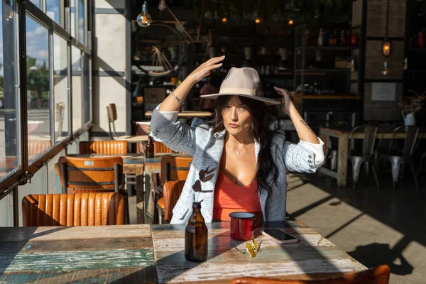 Donna Che Mette Cappello Testa Mentre Rilassa Seduta Una Caffetteria — Foto Stock