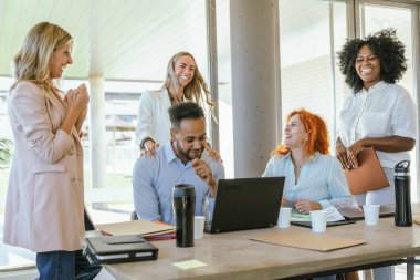 Ofiste birlikte vakit geçirirken gülümseyen çok ırklı iş arkadaşları. İş konsepti.