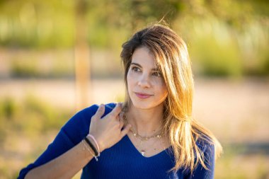 Güneşli bir günde açık havada eğlenirken rahat bir kadın başka tarafa bakıyor..