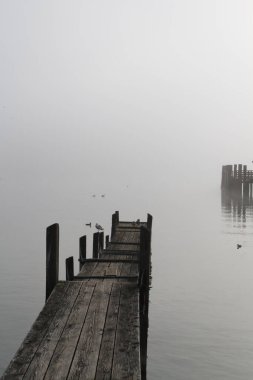 Ahşap tekne iskelesi Sabah güneşi sisli