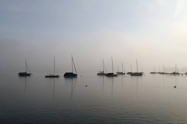 Sabah sisinde Ammersee Gölü 'nde yelkenli tekneler.