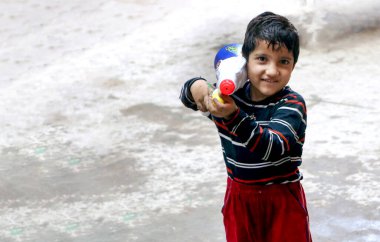 March 20222, Hisar, Haryana : Indian children celebrating Holi with colors and pichkari during Holi festival