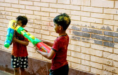 March 20222, Hisar, Haryana : Indian children celebrating Holi with colors and pichkari during Holi festival