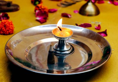 Pooja ve Aarti 'nin yakın çekimi için tabakta yanan fitili olan metalik gümüş bir stand diya ya da lamba. seçici odak
