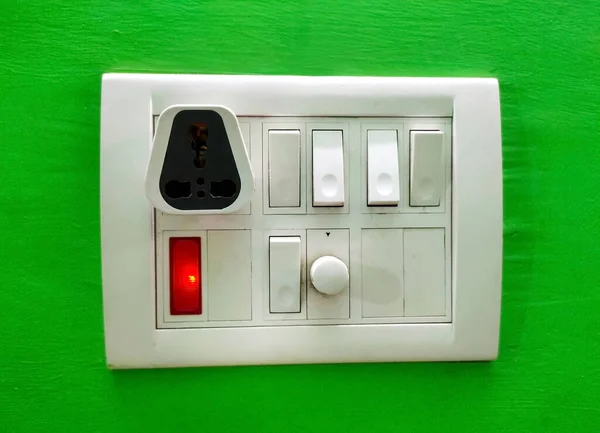 绿色墙壁隔离的模块化白色电源开关和插座板 现代家庭墙壁的最佳电气开关图像 — 图库照片