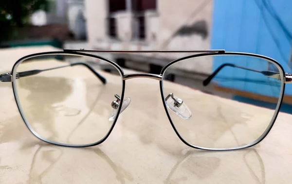 Balkon Duvarında Metal Çerçeveli Şık Gözlükler Bulanıklıktan Keskinliğe Doğru Giden — Stok fotoğraf