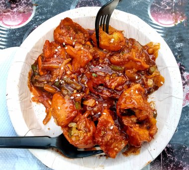 Tek kullanımlık tabakla süslenmiş bir Sebze Mançuryalı Momo resmi.