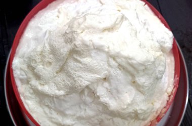 Masanın üzerinde kırmızı bir kase ev yapımı tereyağı.