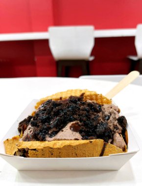 Lokantada tek kullanımlık konteynırda servis edilen çikolata soslu çikolatalı dondurmalar.