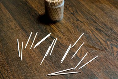 Kürdan kavanozu ve içinde bir sürü kürdan var. Bir masaya yerleştirilen kürdanların seçici odak noktası