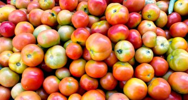 Yerel bir markette yakalanan canlı ve renkli domates yığını..