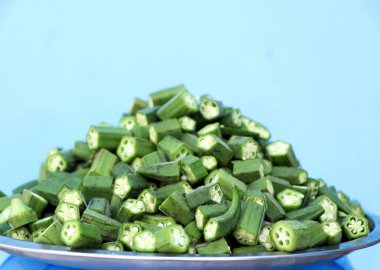 Paslanmaz çelik bir tabakta taze doğranmış bamya (ladyfinger / bhindi). Yemek bloglarında, yemek hazırlama konseptlerinde veya mutfak stoklarında kullanım için ideal