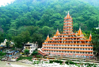 Rishikesh, Hindistan, 22 Haziran 2024: Muhteşem Trayambakeshwar Tapınağı, 13 katlı bir mimari mucize, Uttarakhand, Uttarakhand, Hindistan 'daki Ganj Nehri kıyısında zarif bir şekilde duruyor.