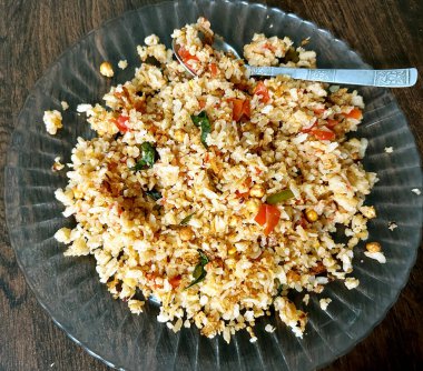 Bir tabak taze hazırlanmış poha, yassı pirinç, soğan, domates, baharat ve baharatla yapılmış popüler bir Hint kahvaltı tabağı.