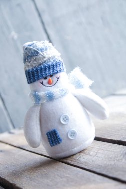 Eski bir geçmişi olan dost canlısı bir kardan adam. Sevimli Noel oyuncağı.